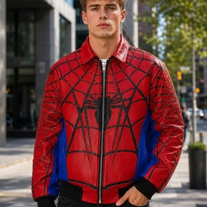 Spider-inspired red and blue faux leather bomber jacket with black web pattern, zip-front closure, and ribbed cuffs, modeled outdoors in a city setting, superhero cosplay costume for men and women.