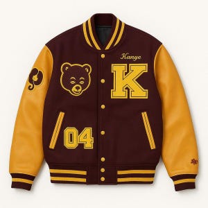 May include: A maroon and gold varsity jacket with leather sleeves. The jacket features a bear patch, the name "Kanye", the letter "K", and the number "04". The jacket has a striped collar, cuffs, and hem.