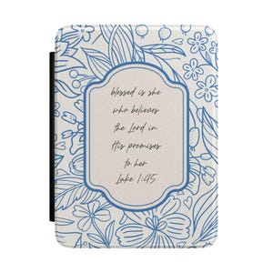 May include: A rectangular e-reader cover featuring a white background with a blue line-art floral pattern. A central beige label with a blue border contains the black text: blessed is she who believes the Lord in His promises to her Luke 1:45.