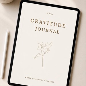 Puede incluir: Una tableta digital que muestra la portada de un diario de gratitud con fondo crema, texto marrón que dice 30 days, GRATITUDE JOURNAL y WRITE TO RETURN YOURSELF, con un dibujo lineal marrón de una flor de lirio en el centro.