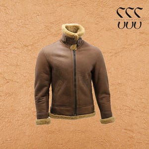 Puede incluir: Chaqueta de cuero marrón con cuello y forro de borrego. La chaqueta tiene cremallera frontal, bolsillos y ribete de borrego en los puños y el dobladillo. Fondo marrón texturizado.