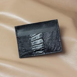 Puede incluir: Un juego de tres tazas de cerámica con un acabado moteado y mate. Las tazas son en tonos crema, gris claro y gris oscuro. Cada taza tiene un diseño simple y minimalista y un asa redondeada. Las tazas están apiladas una encima de otra.