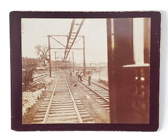 Fotografía antigua de ferrocarril: Hombres negros históricos trabajando en las vías de trenes de vapor y eléctricos.