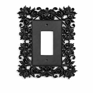 May include: Black, ornate light switch cover with a rectangular center opening. The cover features a detailed floral and scroll design around the edges. The cover is made of a solid, matte black material and is designed to fit a single-gang switch.