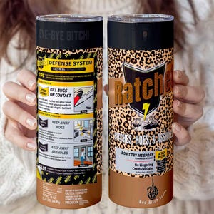 Puede incluir: Se muestran dos botellas de spray cilíndricas. Una presenta un diseño de estampado de leopardo y la palabra "Ratche" en dorado. La otra tiene las palabras "Defense System" y "Kill Bugs On Contact".
