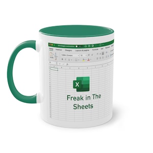 Può includere: Tazza in ceramica bianca con interno e manico verdi. La tazza presenta un design stampato di foglio di calcolo Excel con il testo "Freak in The Sheets" e il logo Excel.