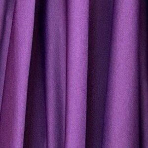 May include: A close-up of a draped fabric in a deep purple hue. The fabric has vertical folds and a soft texture, creating shadows and highlights. The color is consistent throughout the image.