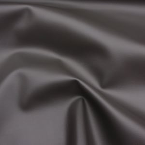 May include: A close-up of a smooth, dark grey fabric with a subtle texture. The fabric is draped and folded, creating soft curves and folds.