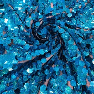 May include: A fabric featuring a dense layer of round, iridescent turquoise sequins attached to a sheer mesh base. The sequins are arranged in a swirling pattern, creating a textured surface with a reflective, glittery finish in shades of blue.