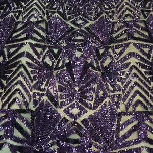 May include: Purple and black sequined fabric with a geometric pattern. The sequins are arranged in a repeating pattern of triangles and diamonds.
