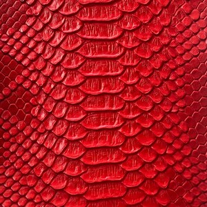 May include: Close-up of a vibrant red snakeskin pattern. The texture features overlapping, scale-like shapes with a glossy finish. The design is consistent across the surface, creating a bold and eye-catching visual.