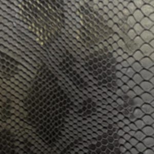 May include: Close-up of a textured, dark gray material with a repeating scale-like pattern. The pattern creates a subtle, three-dimensional effect, suggesting a reptile skin texture. The overall appearance is sleek and modern.