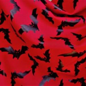 以下が含まれることがあります： 赤い生地に黒いコウモリの模様がプリントされています。コウモリは生地にランダムに散らばっています。