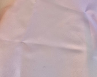 May include: A close-up of a white fabric with a subtle texture. The fabric has a slight sheen and is wrinkled in places.