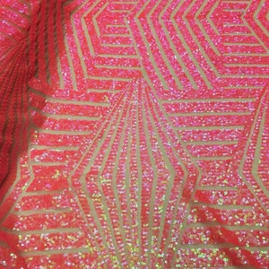 May include: Pink iridescent sequins on a mesh fabric with a geometric pattern. The sequins are arranged in a repeating pattern of lines and shapes.