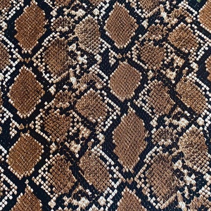 May include: Close-up of a brown and black snakeskin pattern. The pattern is made up of small, overlapping scales.