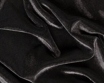 May include: Close-up of a black fabric with a smooth, silky texture. The fabric is draped and folded, creating soft, flowing lines.
