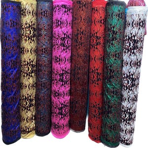 May include: Eight rolls of glittery fabric with a flame pattern in various colors, including blue, gold, teal, pink, red, green, white, and black.