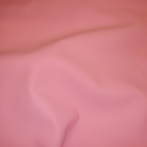 Puede incluir: Un fondo de tela lisa de color rosa s&oacute;lido con arrugas sutiles.