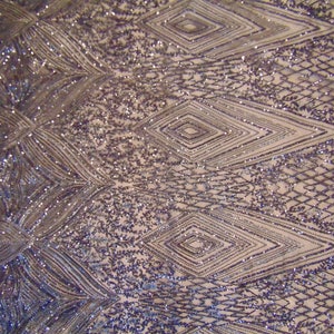 May include: Purple and silver sequined fabric with a geometric pattern. The fabric has a mesh backing.