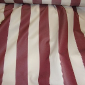 May include: Red and white striped fabric with a smooth texture. The fabric is folded and draped, showing the stripes.