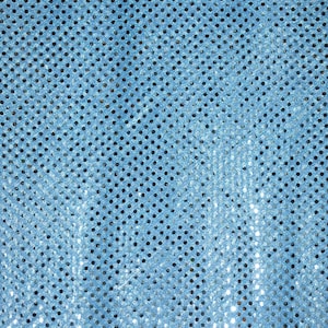 May include: Close-up of a light blue sequin fabric. The fabric is covered in small, round, black holes, creating a dotted pattern. The sequins reflect light, giving the fabric a shimmering appearance. The overall texture is smooth and slightly textured.