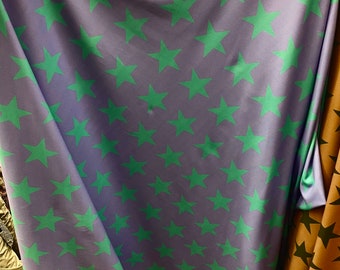 Green stars on black Spandex trixot 4 way stretch fabric 58" wide