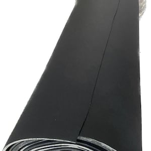 May include: A rolled-up, black foam sheet. The material is tightly wound, revealing layers of gray and black. The top layer is a solid, dark black. The roll is partially wrapped in clear plastic.