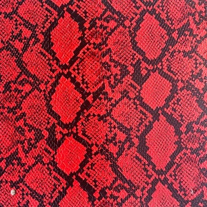 May include: Red and black snakeskin pattern fabric. The fabric has a textured surface and a repeating pattern of black scales on a red background.