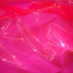 May include: A bright pink, shiny, and translucent fabric with a crinkled texture.
