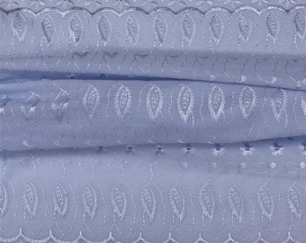 May include: Light blue cotton fabric with a delicate white embroidered pattern of leaves and flowers. The fabric has a scalloped edge.