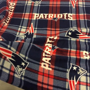 May include: Red, white, and blue plaid fabric with a repeated pattern of the New England Patriots logo and the word "Patriots".