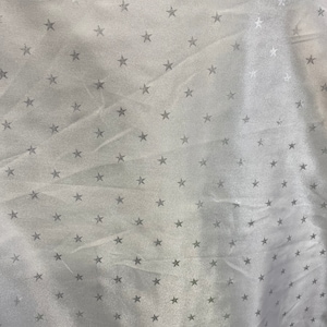 May include: White fabric with a silver star pattern.