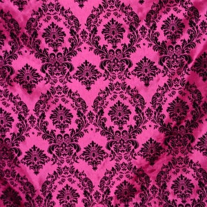 May include: A pink fabric with a black damask pattern. The fabric has a satin-like sheen.
