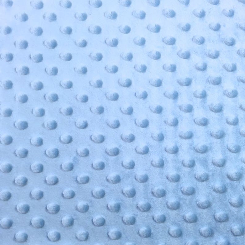 May include: A light blue fabric with a textured pattern of small raised dots. The fabric has a soft, plush feel.