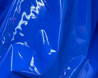 May include: Close-up of a shiny, bright blue fabric with a smooth, glossy finish. The fabric is folded and draped, creating a textured surface.