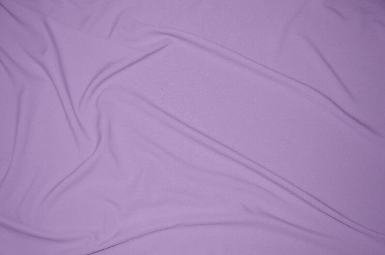 May include: A smooth, light purple fabric with soft folds and wrinkles.