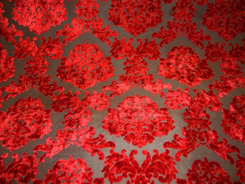 Pode incluir: Tecido de veludo vermelho com um padr&atilde;o de damasco. O tecido tem um design em relevo texturizado.