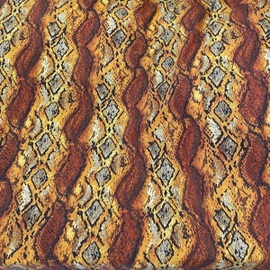 May include: Brown fabric with a snakeskin pattern in gold, black, and white.