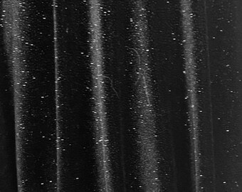 May include: Black fabric with a subtle sparkle, showing the texture of the material. The fabric is draped in folds, creating a soft and elegant look.