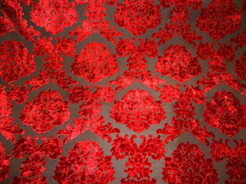 Pode incluir: Tecido de veludo vermelho com um padr&atilde;o de damasco. O tecido tem um design em relevo texturizado.