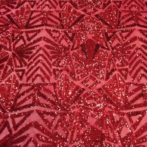 May include: Red sequined fabric with a geometric pattern. The sequins are arranged in a repeating pattern of triangles and diamonds.