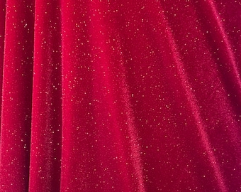 Può includere: Tessuto di velluto rosso con una delicata brillantezza. Il tessuto ha una texture morbida e vellutata e un colore rosso ricco e profondo.