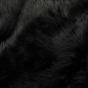 May include: A close-up shot of a black faux fur fabric. The fur has a long, shaggy pile with a soft, textured appearance. The lighting creates shadows and highlights, adding depth to the material. The overall look is luxurious and inviting.