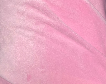 May include: A close-up of a soft, pink fabric with a fuzzy texture. The fabric is folded in half, creating a diagonal line across the image.