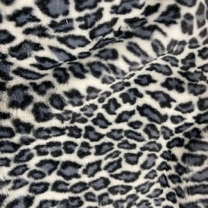 May include: A close-up of a white and gray faux fur fabric with a leopard print pattern.
