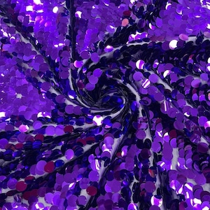 May include: A fabric material densely covered in round, reflective purple sequins. The sequins are arranged in a swirling, vortex-like pattern that creates a sense of depth and movement across the surface, with light reflecting off the metallic finish.