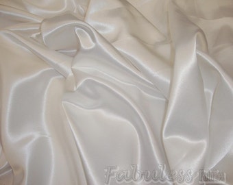 May include: White satin fabric with a smooth, silky texture. The fabric is draped and folded, showcasing its luxurious feel.