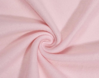 May include: Close-up of a swirl of soft, light pink fabric. The material appears to be a plush, possibly fleece or flannel, with a smooth texture and subtle folds. The fabric is evenly lit, highlighting its delicate color and texture.