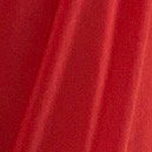 May include: A close-up of a smooth, red fabric with a subtle sheen. The fabric is folded and draped, creating soft, flowing lines.